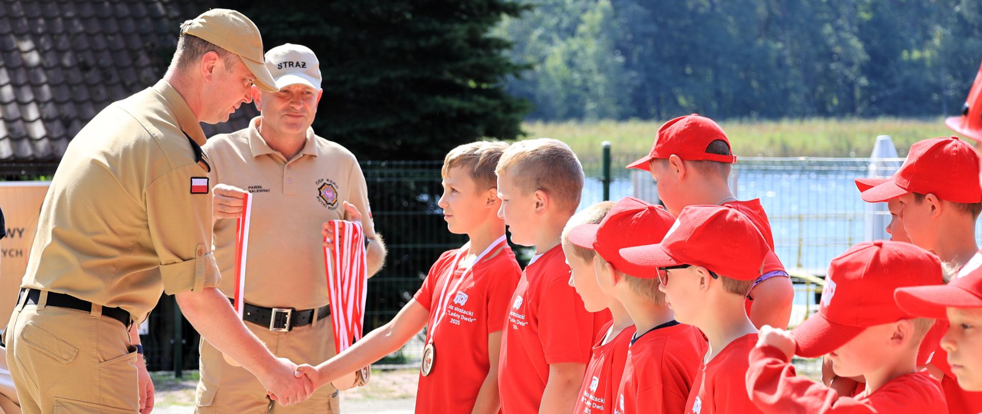 Zastępca podlaskiego komendanta wojewódzkiego Państwowej Straży Pożarnej - st. bryg. Marcin Wierel gratulował uczestnikom obozu i wręczał medale pamiatkowe
