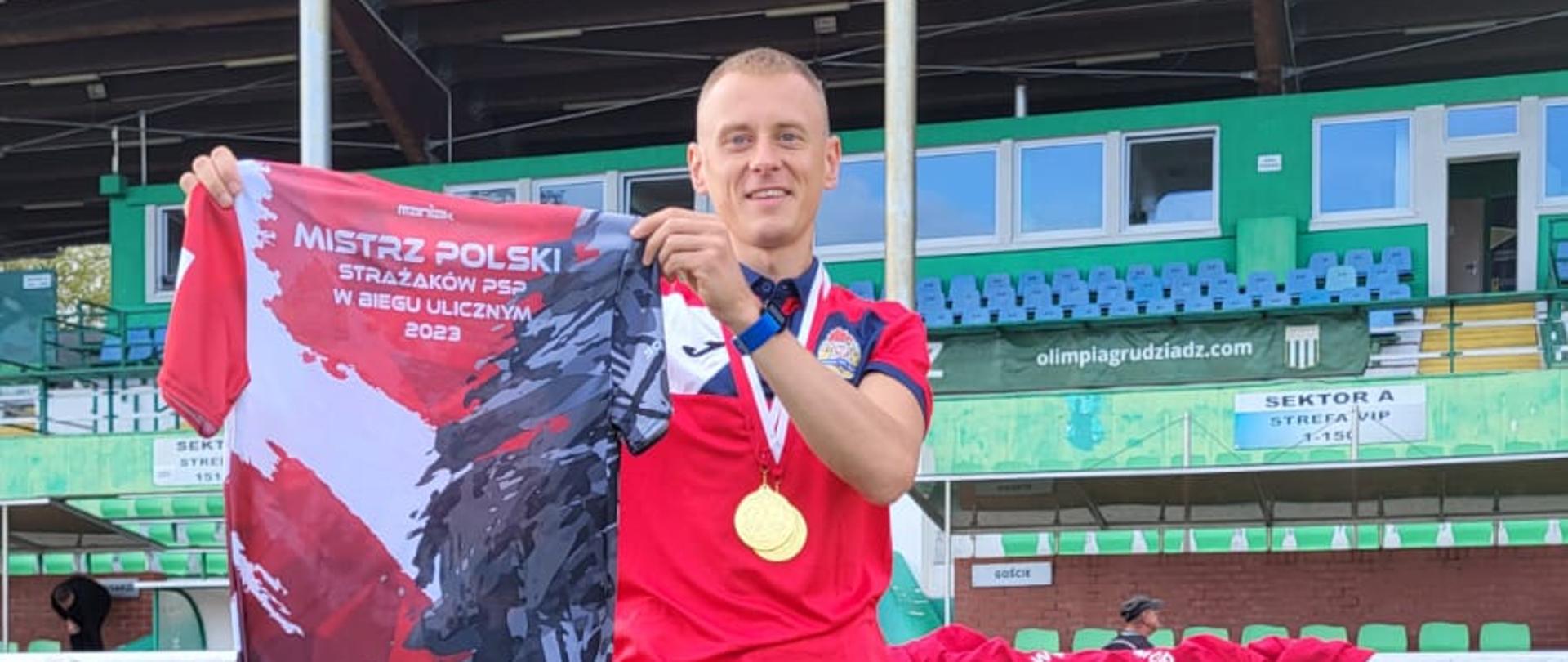 Przemysław Ratajczyk z trofeami za zajęcie I miejsca w Mistrzostwach STrażaków w biegu ulicznym