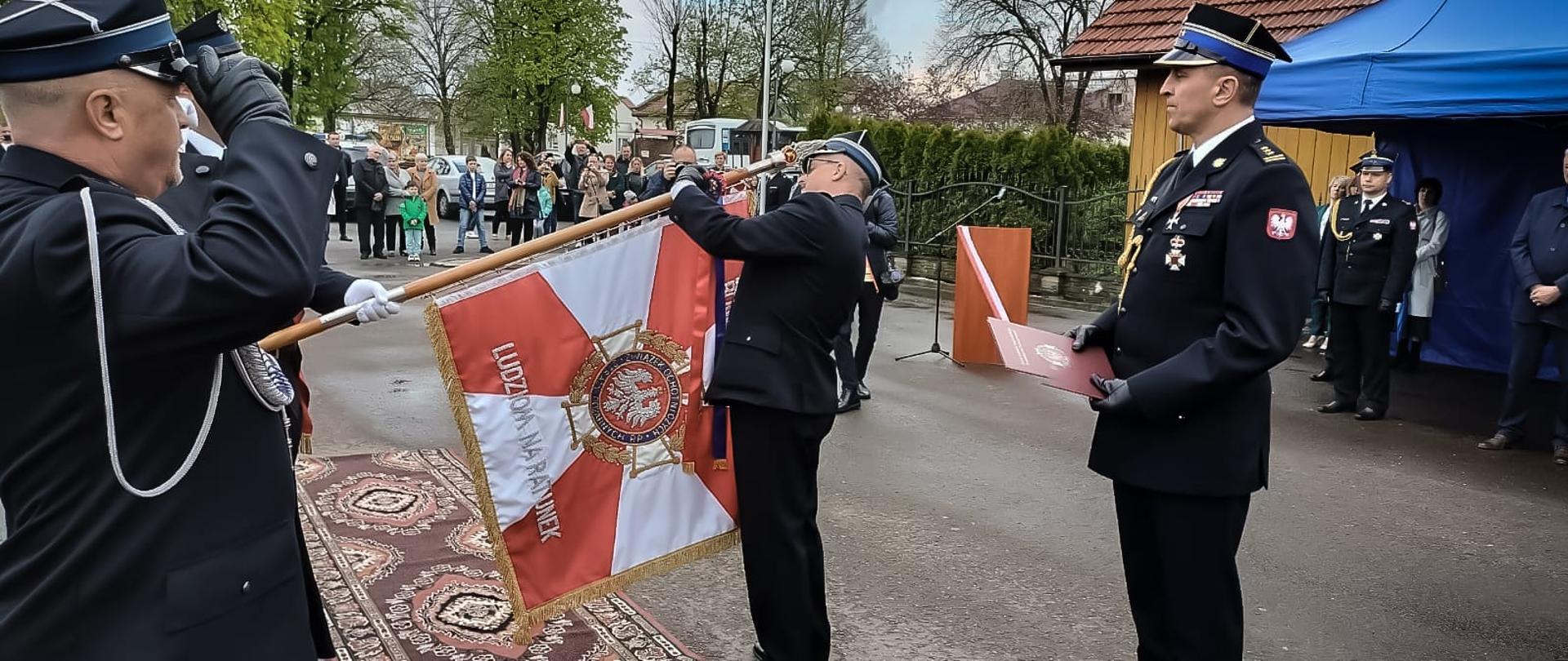 Zdjęcie zrobione na zewnątrz, podczas uroczystości 130- OSP Osiek Jasielski. Na zdjęciu uczestnicy uroczystości.