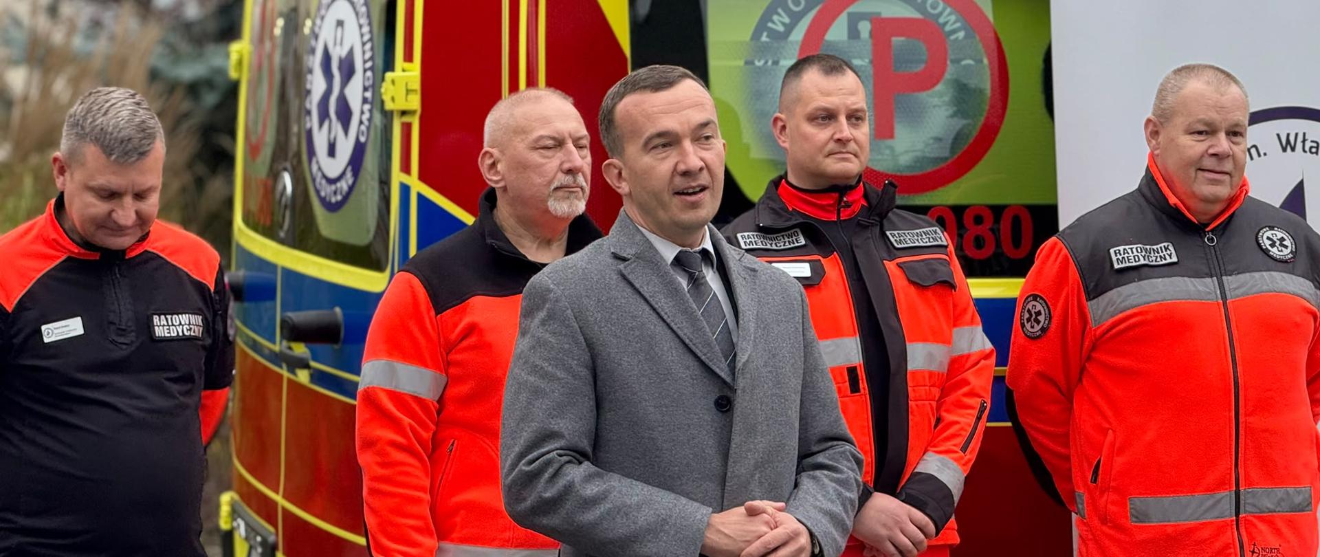 Mężczyzna wypowiada się na tle karetki 