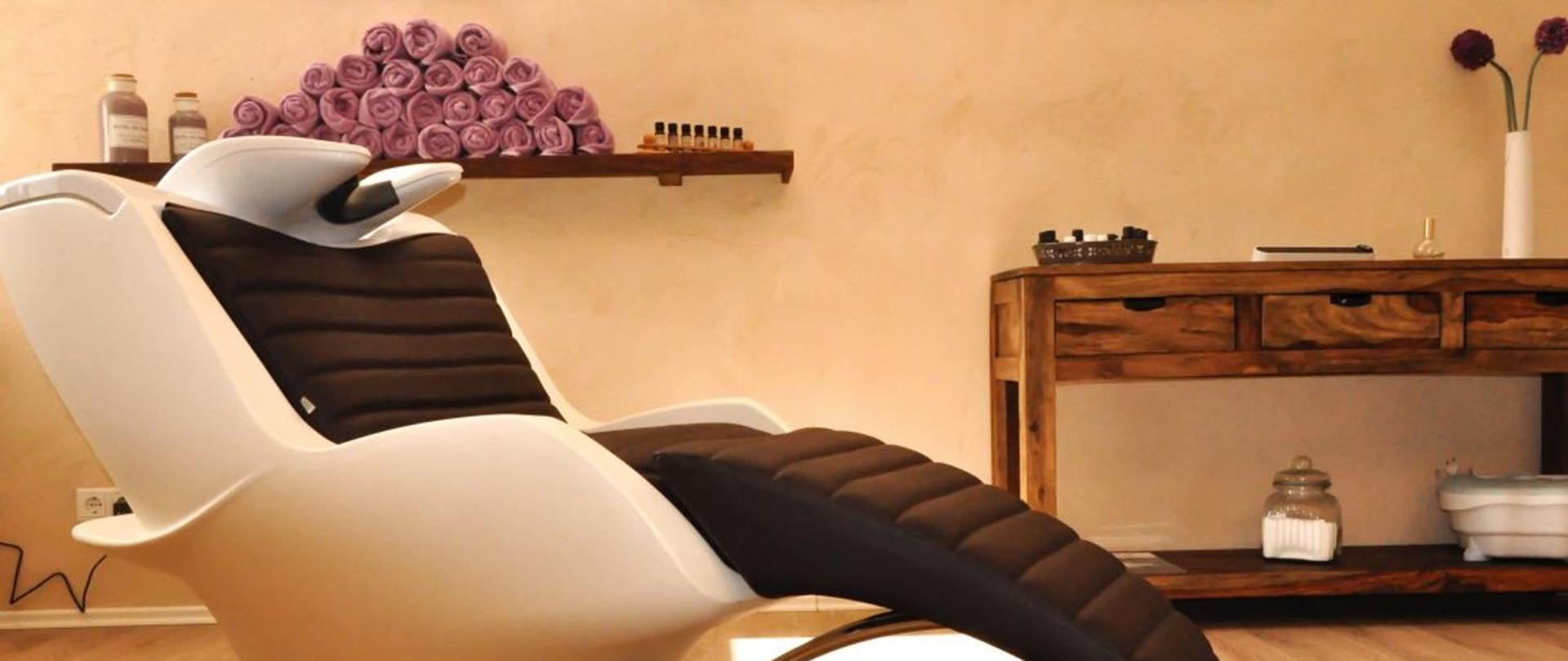 Zdjęcie obrazujące typowe pomieszczenie salonu kosmetycznego- fotel- meble i półka z kosmetykami i ręcznikami do wykonywania usług w zakresie branży beauty