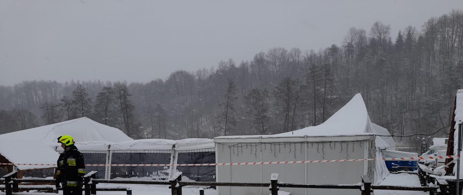 Strażak zabezpiecza teren akcji.