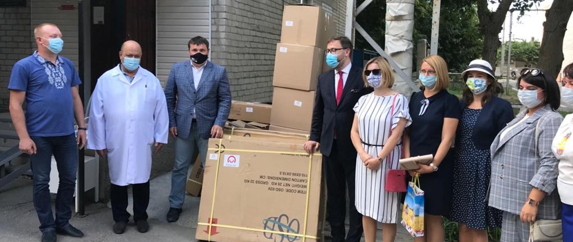 grupa osób stoi przed budynkiem.