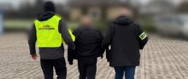 Funkcjonariusze KAS i CBŚP prowadzą zatrzymanego mężczyznę