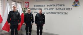Trzech funkcjonariuszy stoi w szeregu na świetlicy Komendy. 