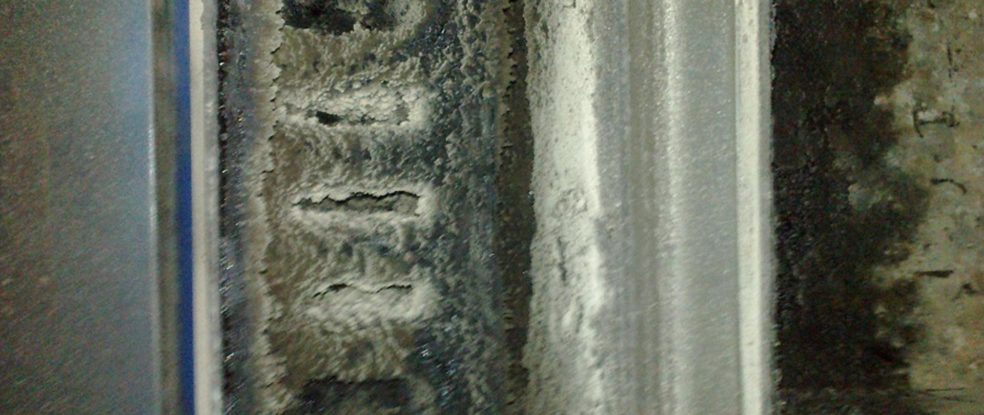 Zabrudzone wnętrze komina spalinowego.