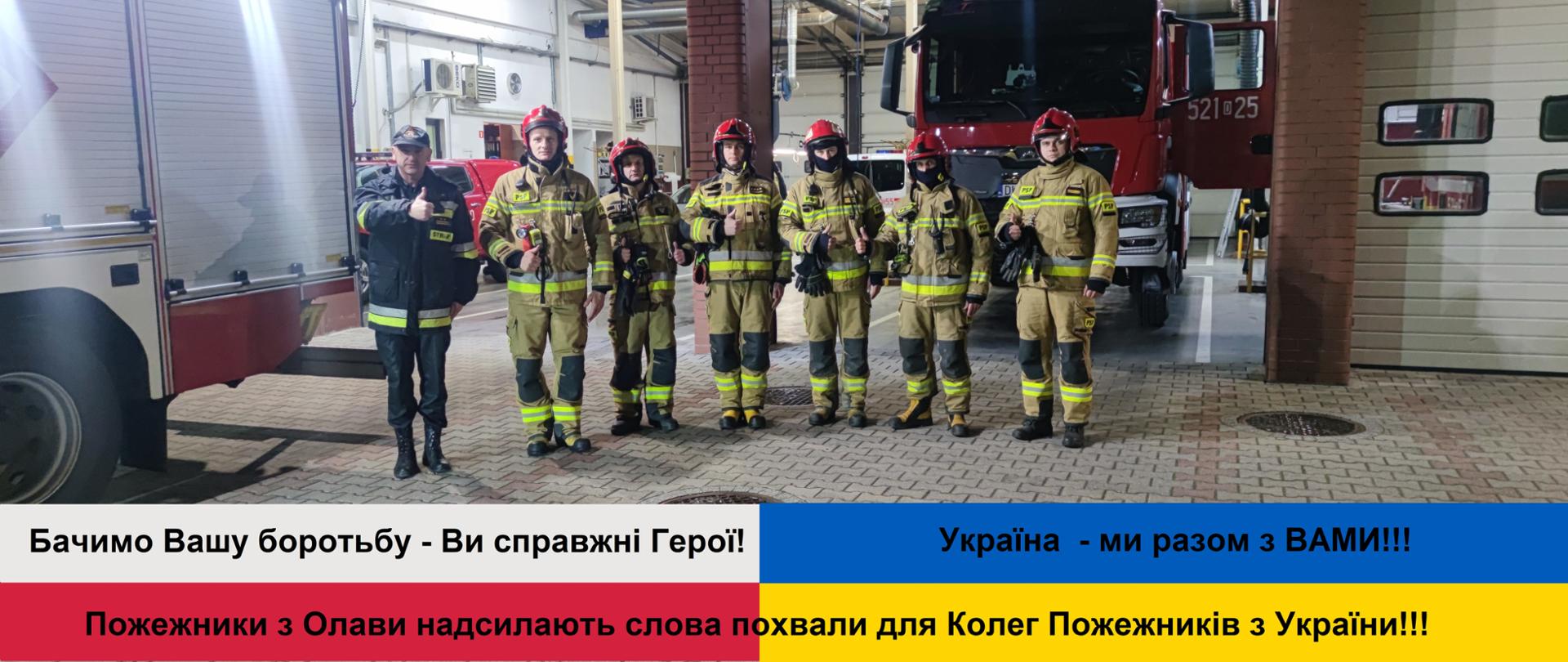 na zdjęciu widać strażaków z Oławy w bojowych mundurach. Pod spodem flaga Polski i Ukrainy oraz tekst:
Widzimy Waszą walkę – jesteście prawdziwymi Bohaterami
Strażacy z Oławy wysyłają słowa uznania dla Kolegów Strażaków z Ukrainy
!!! Ukraina – jesteśmy z WAMI !!!
Бачимо Вашу боротьбу - Ви справжні Герої! Пожежники з Олави надсилають слова похвали для Колег Пожежників з України!!! Україна - ми разом з ВАМИ!!!