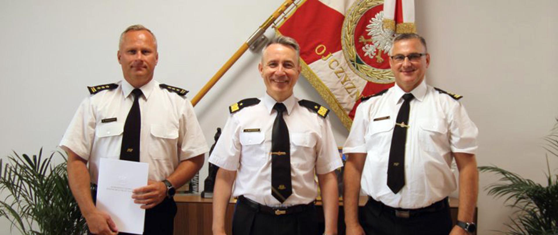 Komendant główny Państwowej Straży Pożarnej powołał st. bryg. mgr. inż. Roberta Wiśniewskiego na stanowisko zastępcy kujawsko-pomorskiego komendanta wojewódzkiego PSP w Toruniu – zdjęcie zbiorowe na tle Sztandaru.