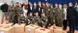 Grupowe zdjęcie uczniów klasy mundurowej Zespołu Szkół nr 1 w Myszkowie, w towarzystwie europosłanki Jadwigi Wiśniewskiej oraz nauczycieli. Przed nimi ustawione paczki