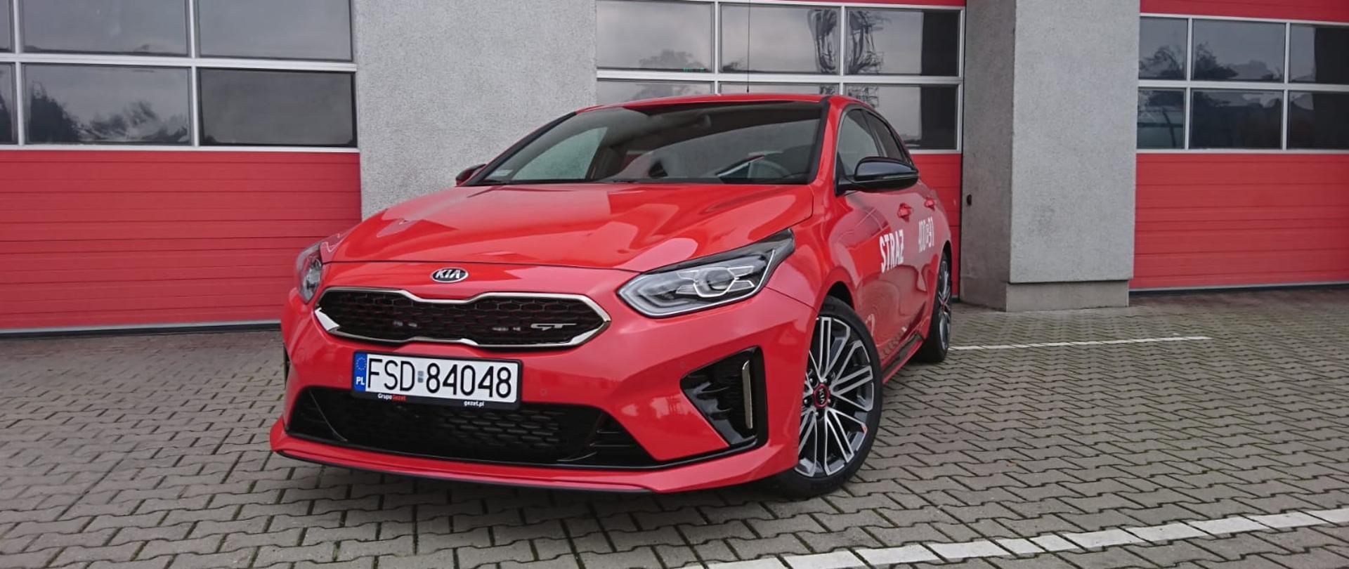 Zdjęcie przedstawia samochód osobowy KIA proceed, widok lewego przodu z perspektywą na lewy bok pojazdu, auto zaparkowane na placu wewnętrznym komendy