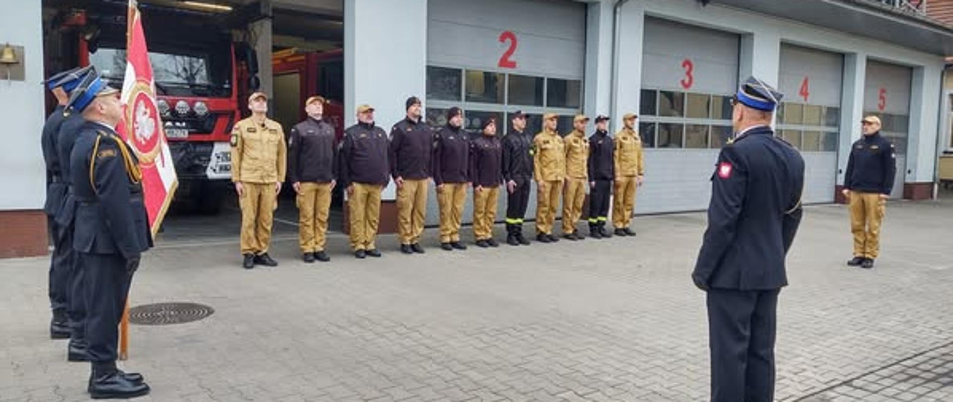 Zmiana służbowa, poczet sztandarowy oraz Komendant Powiatowy na placu prze jednostka podczas uroczystej zbiórki