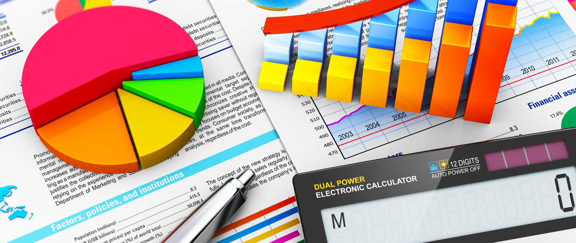 Kalkulator, długopis oraz dane w postaci kolorowych grafów na tle wykresów