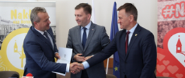Wojewoda Mikołaj Bogdanowicz w obecności ministra Łukasza Schreibera wręcza burmistrzowi Nakła Sławomirowi Napierale promesę na drogę w Polichnie