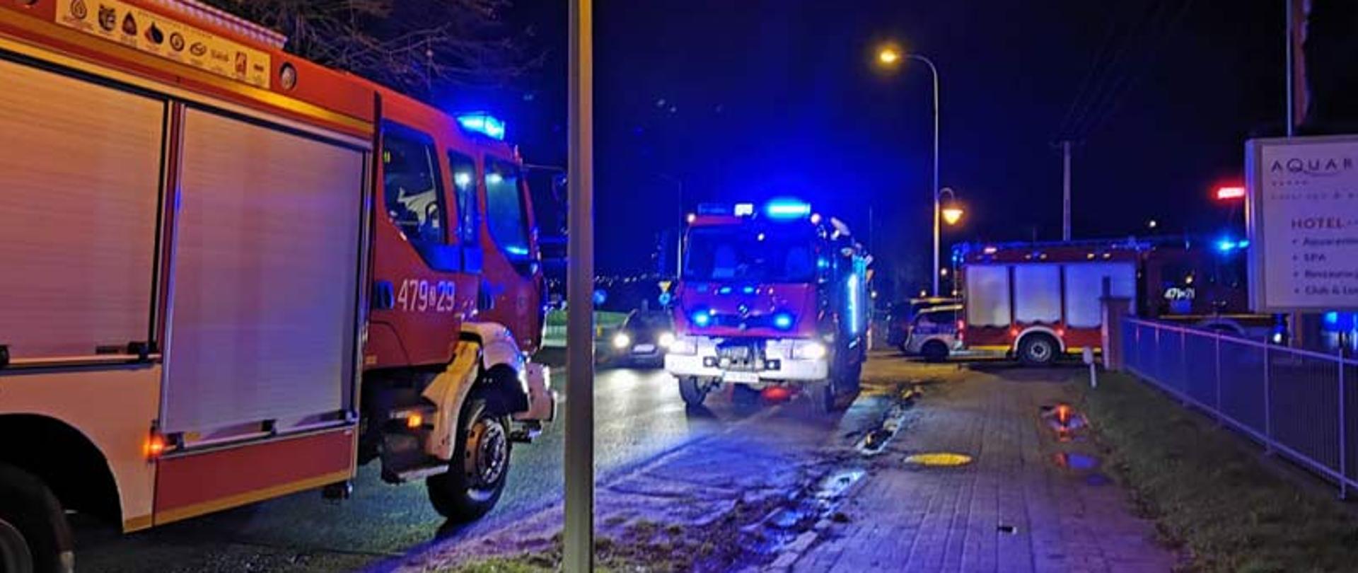 Samochody strażackie z włączonymi światłami zaparkowane wzdłuż ulicy