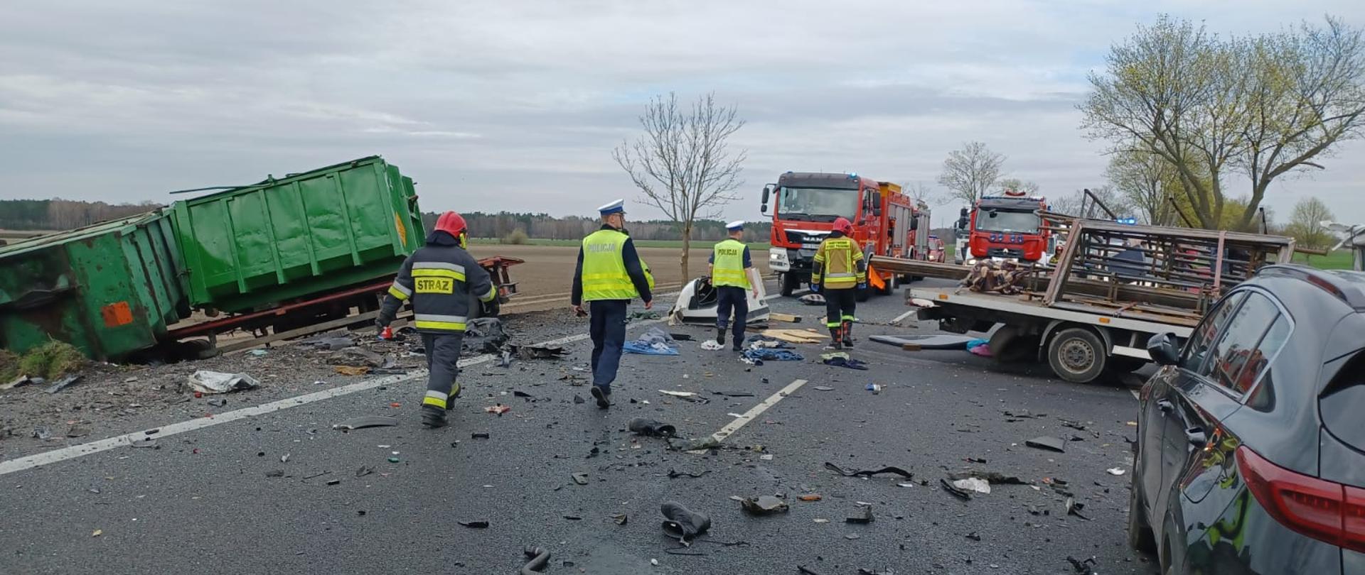 Na zdjęciu częściowo widać rozbite pojazdy strażaków oraz policjantów oraz w tle samochody pożarnicze.