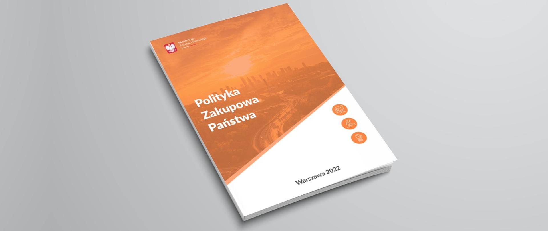 Polityka Zakupowa Państwa. Na zdjęciu widać książkę pomarańczowo białą, zatytułowaną Polityka Zakupowa Państwa.