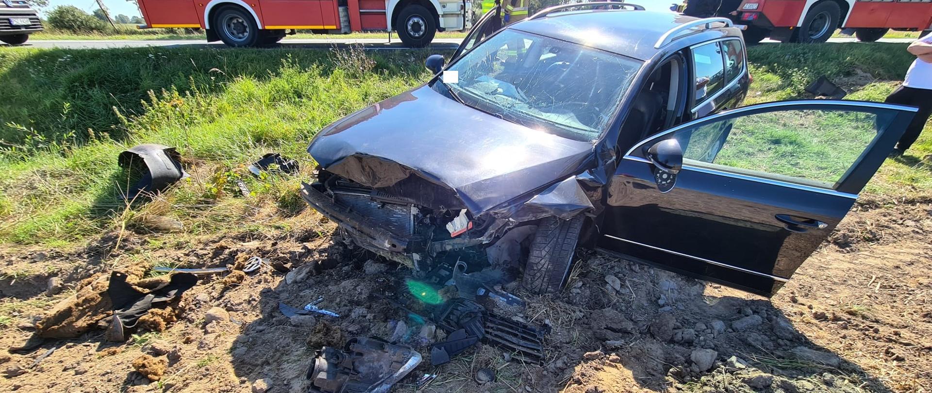 Widać uszkodzony przód samochodu, który jest na polu