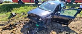 Widać uszkodzony przód samochodu, który jest na polu