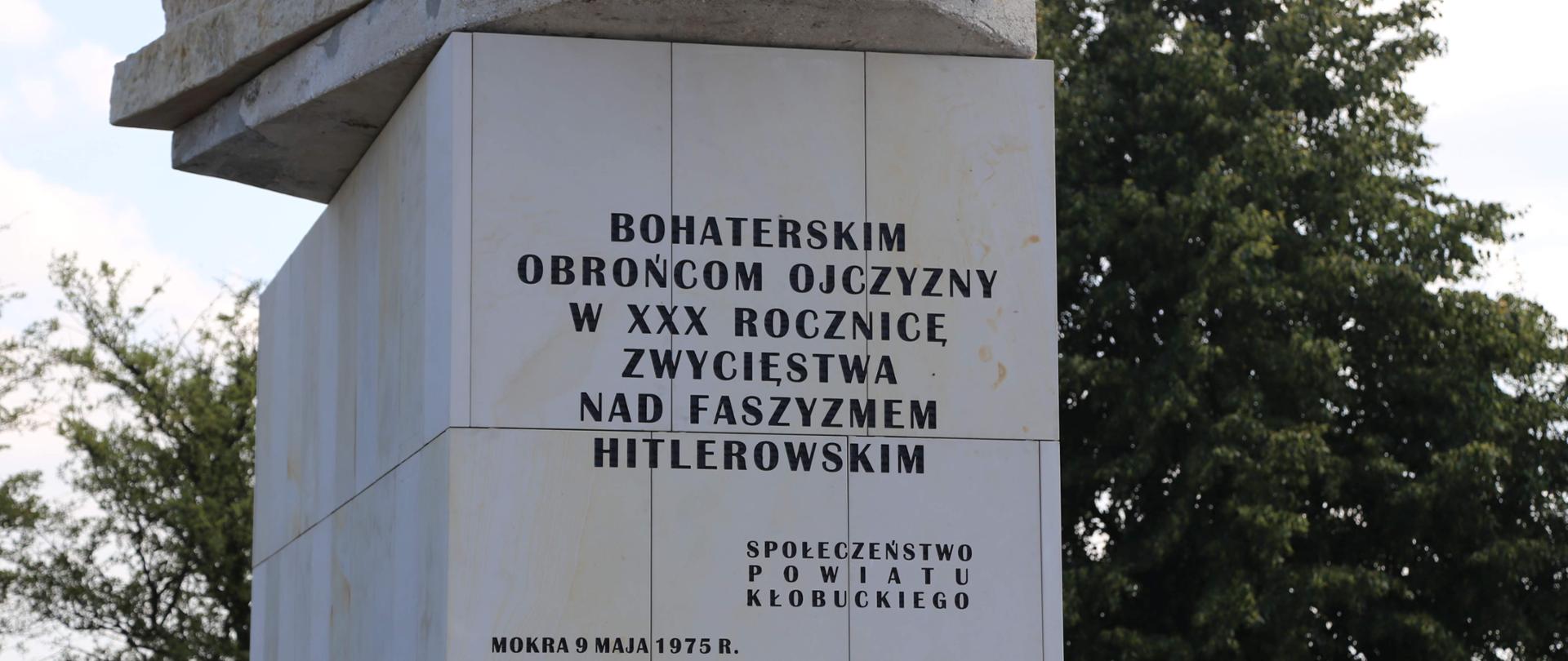Cokół pomnika ku czci bohaterów bitwy pod Mokrą. Na cokole widnieje napis "Bohaterskim obrońcom ojczyzny w XXX rocznicę zwycięstwa nad faszyzmem hitlerowskim"