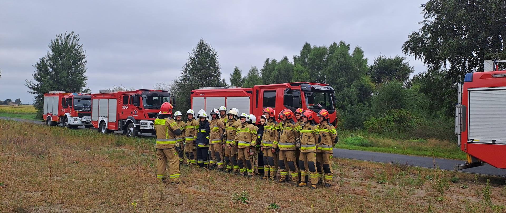 Ćwiczenia plutonu gaśniczego "RADZIEJÓW" wchodzącego w skład 3 kompanii gaśniczej "KUJAWIAK"
Zdjęcie przedstawia teren lasu w miejscowości Przysiek, strażaków PSP oraz OSP podczas odprawy przed rozpoczęciem ćwiczeń oraz wozy bojowe koloru czerwonego.