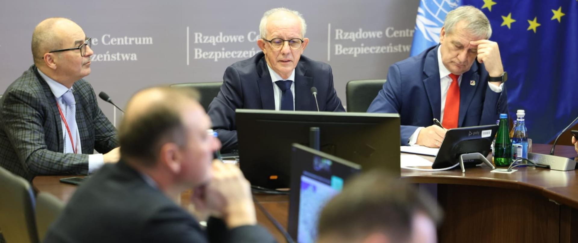 kilku mężczyzn rozmawia w Rządowym Centrum Bezpieczeństwa