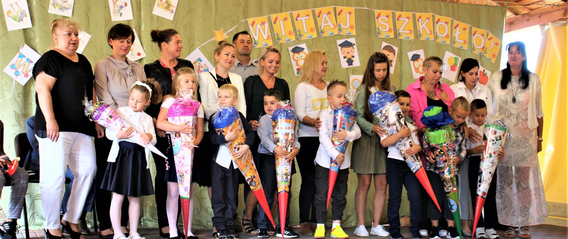 Rodzice z dziećmi trzymający tyty pierwszaka