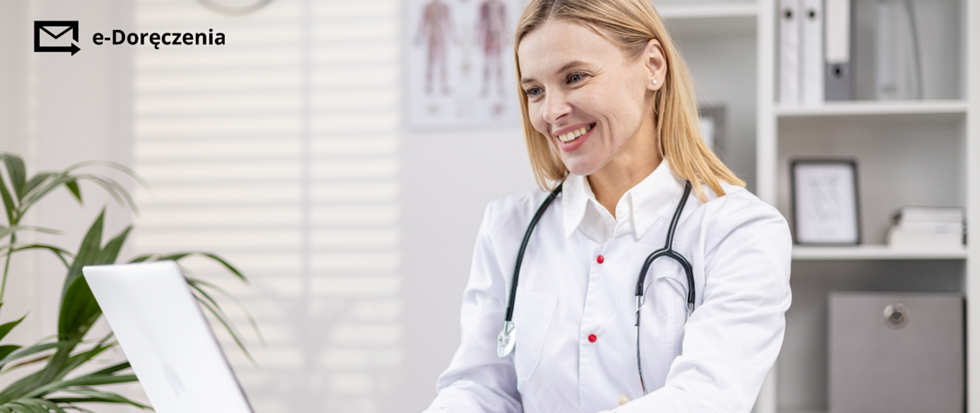 Uśmiechnięta Pani doktor patrząca na ekran laptopa. 
