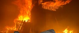 Zdjęcie przedstawia rozwinięty pożar w budynku. 