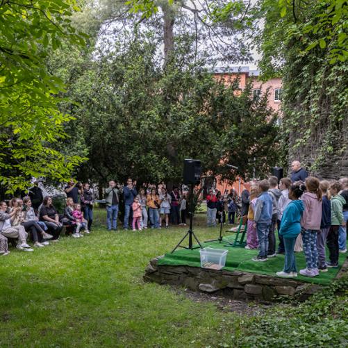 dzieci występujące podczas pikniku oraz słuchająca ich publiczność