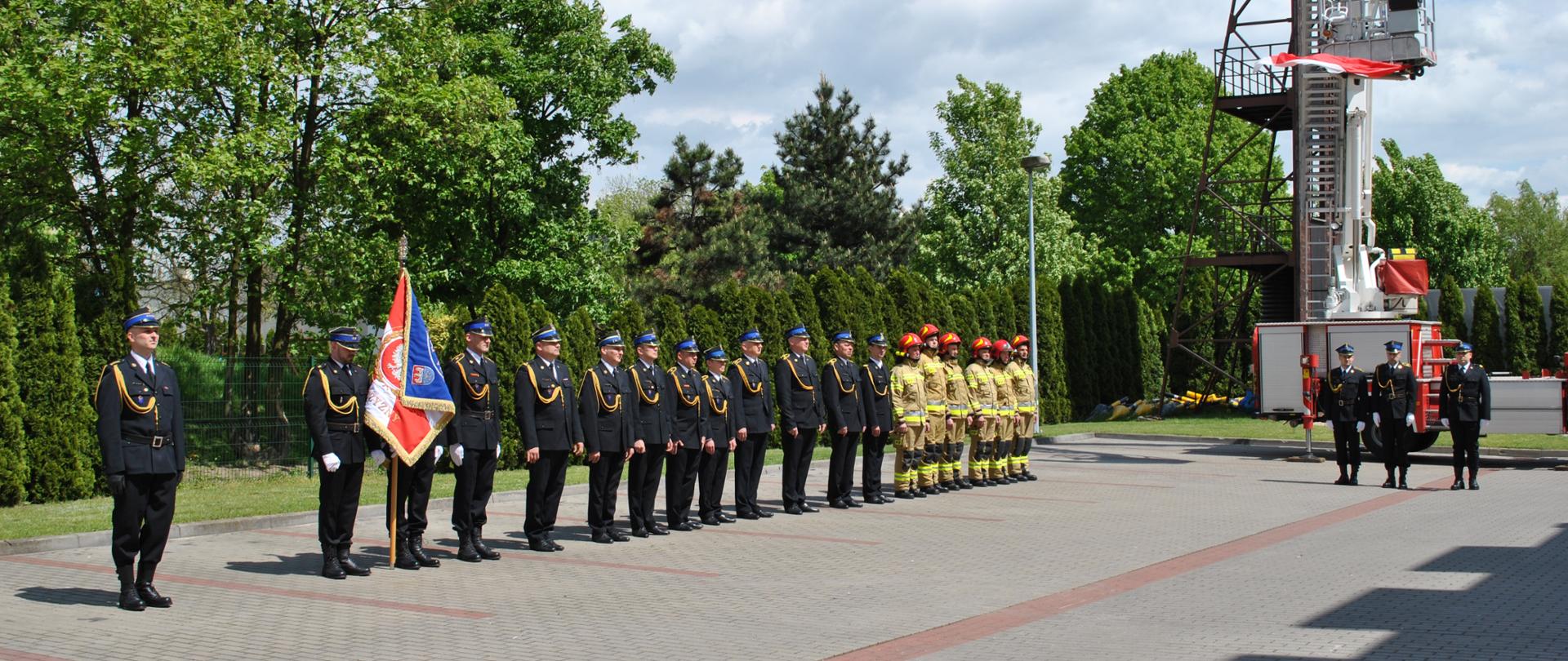 Pododdział strażaków stoi 