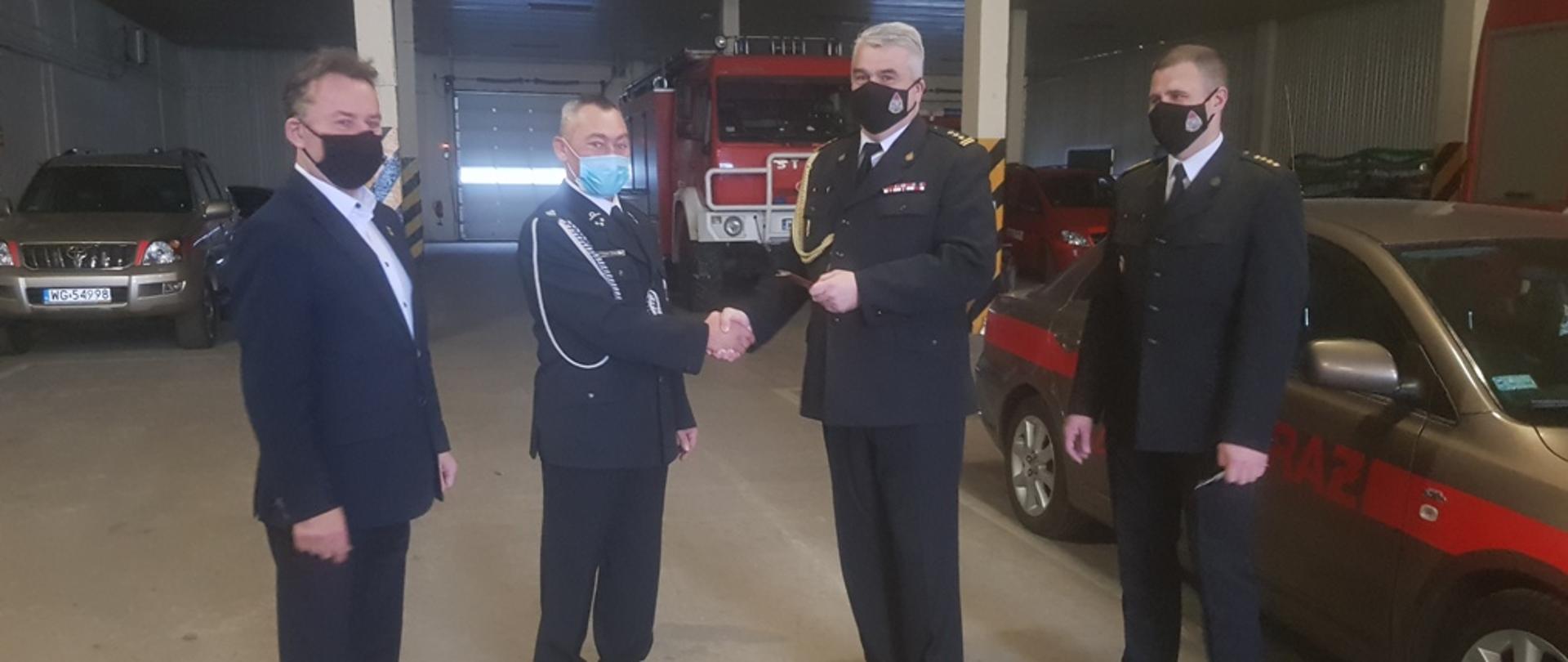 Komendant PSP wraz z Zastępcą ubrani w mundury wyjściowe przekazują samochód osobowy Naczelnikowi OSP Górzno. Dodatkowo w przekazaniu bierze udział Wójt gminy Górzno jednocześnie prezes Zarządu Oddziału Powiatowego Związku OSP RP w Garwolinie. Przekazanie ma miejsce na Garażu Komendy PSP w Garwolinie.