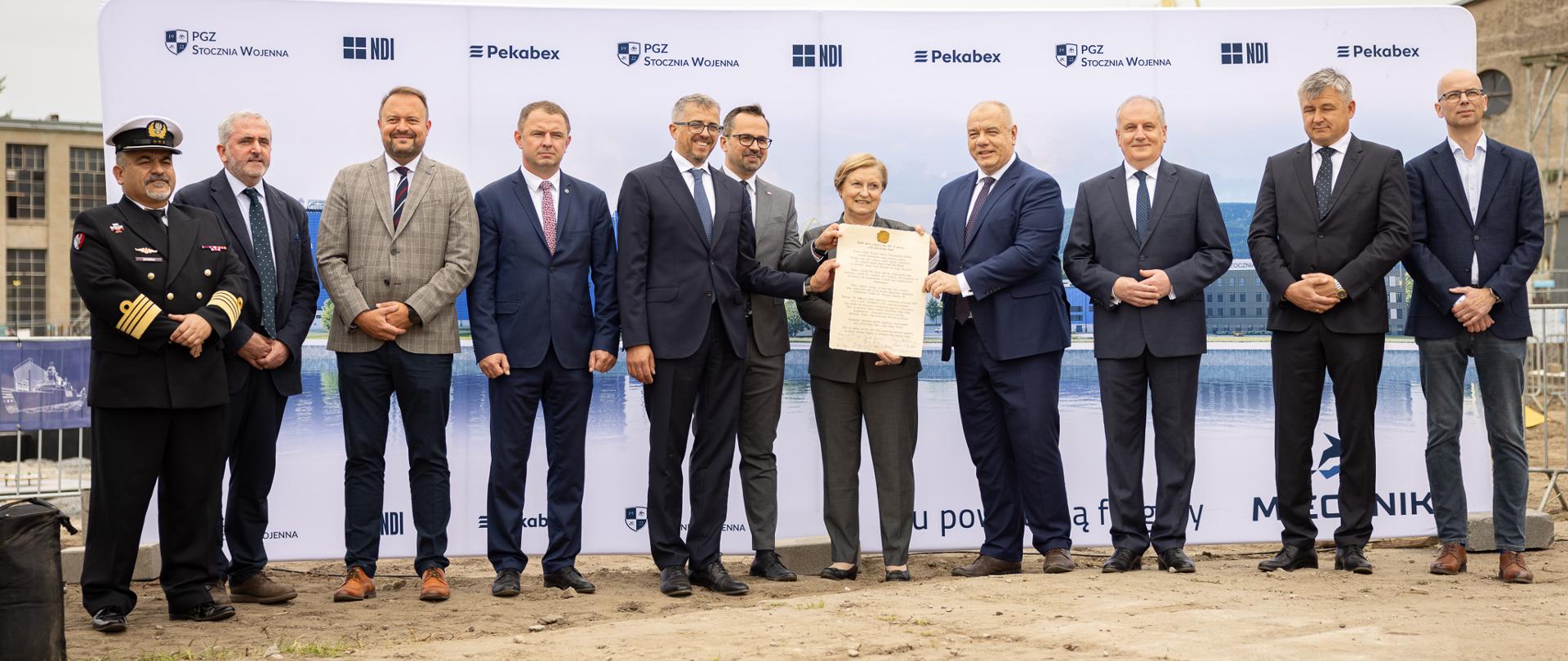 Uczestnicy trzymają w dłoniach podpisany Akt Erekcyjny. 