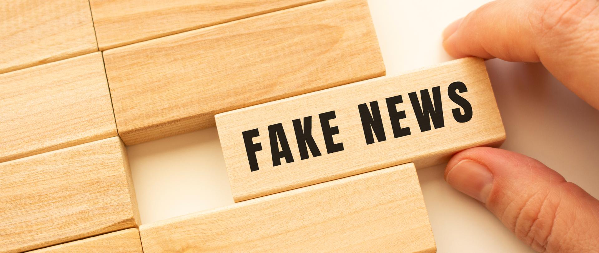 drewniane klocki, na jednym z nich jest napis fake news