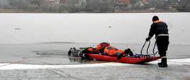 Zdjęcie przedstawia ćwiczących strażaków podczas ćwiczeń na lodzie
