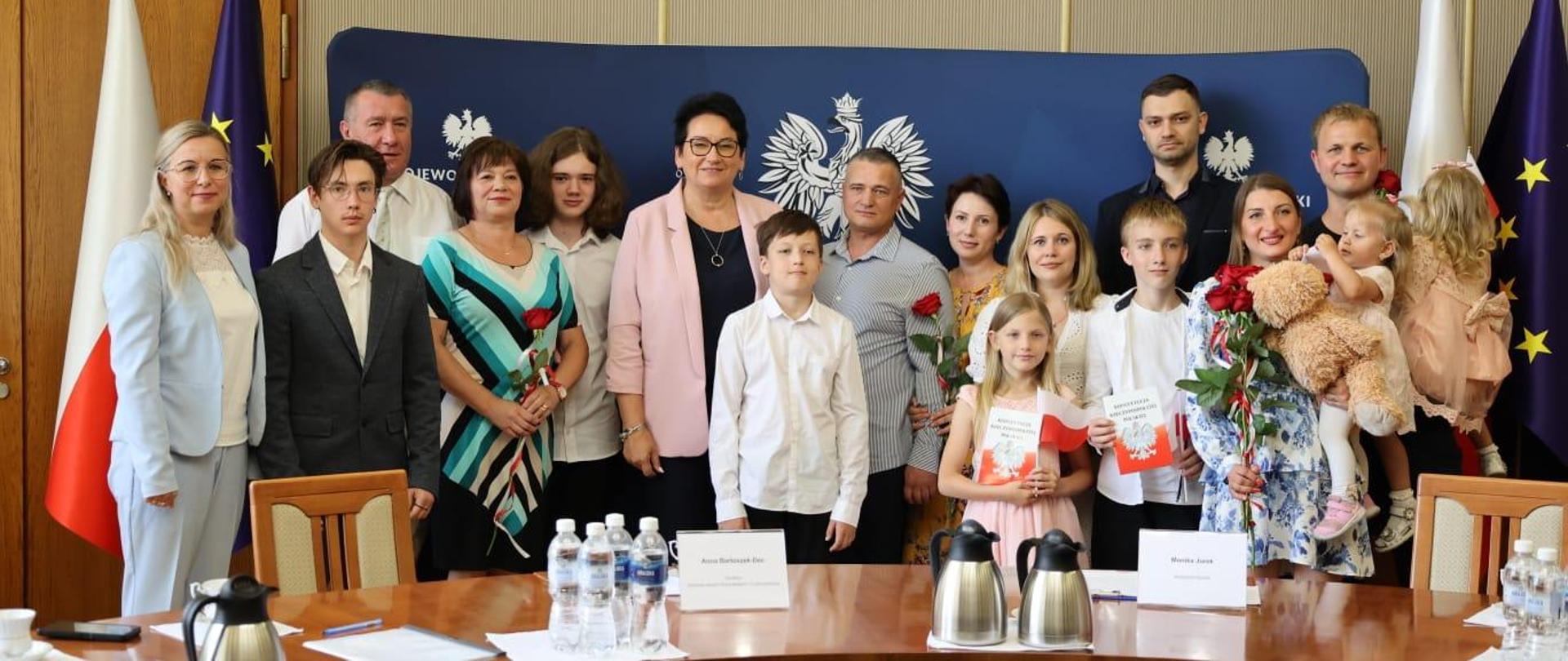 Na zdjęciu Wojewoda Opolski Monika Jurek razem z Dyrektor Wydziału Spraw Obywatelskich i Cudzoziemców Anną-Bartoszek Dec pozują do zdjęcia z nowymi obywatelami po uroczystości nadania obywatelstwa polskiego. 