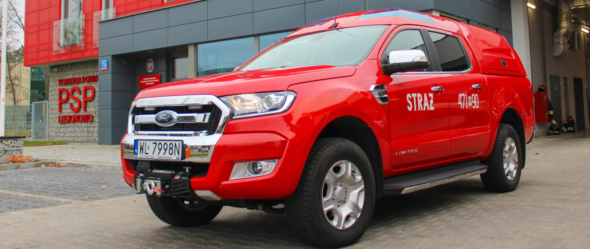 Lekki Samochód Rozpoznawczo - Ratowniczy Ford Ranger - JRG Legionowo. Na zdjęciu przed komendą samochód osobowy czerwony o nr. operacyjnym 471 - 90 Widok lewy przód. 
