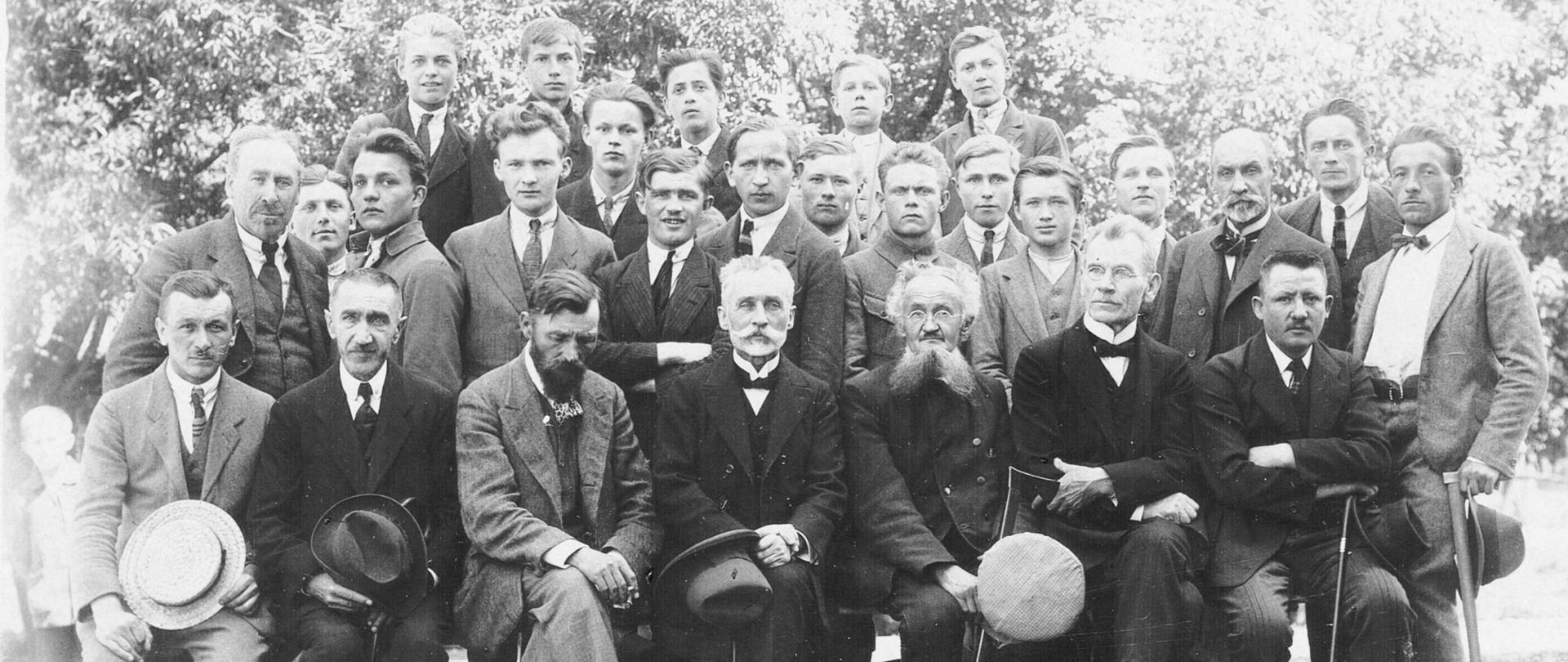 Na zdjęciu znajdują się uczniowie i grono pedagogiczne Państwowej Szkoły Przemysłu Drzewnego w Zakopanem. W pierwszym rzędzie w środku postać siedząca z kapeluszem - Dyrektor Szkoły Stanisław Barabasz.