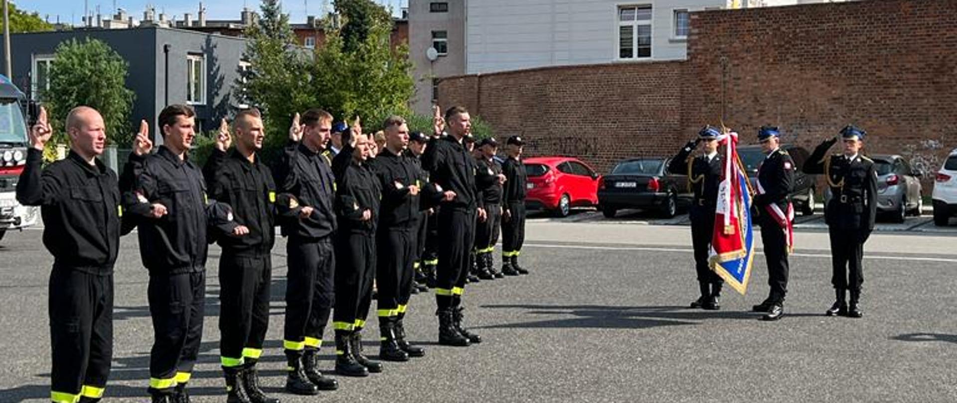 Strażacy stoją w tle budynki