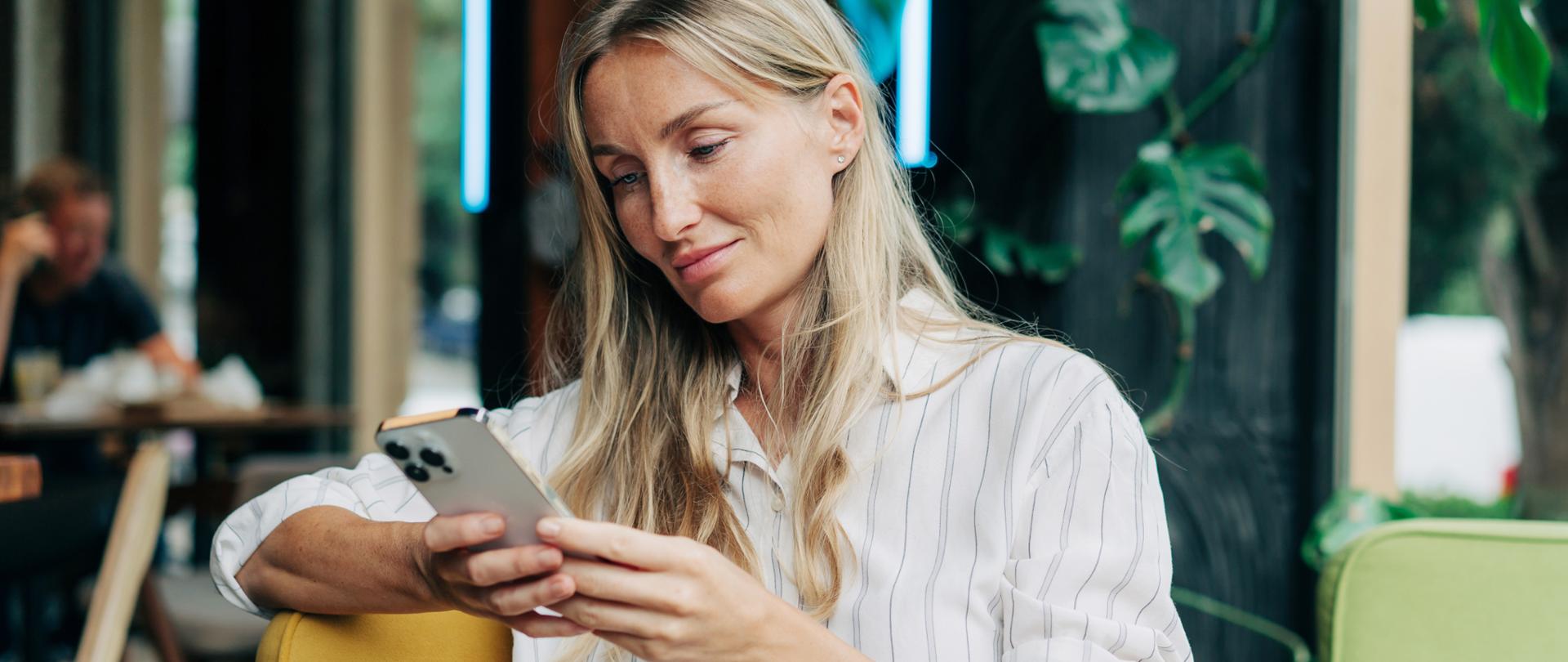 Trzymająca smartfon w rękach kobieta