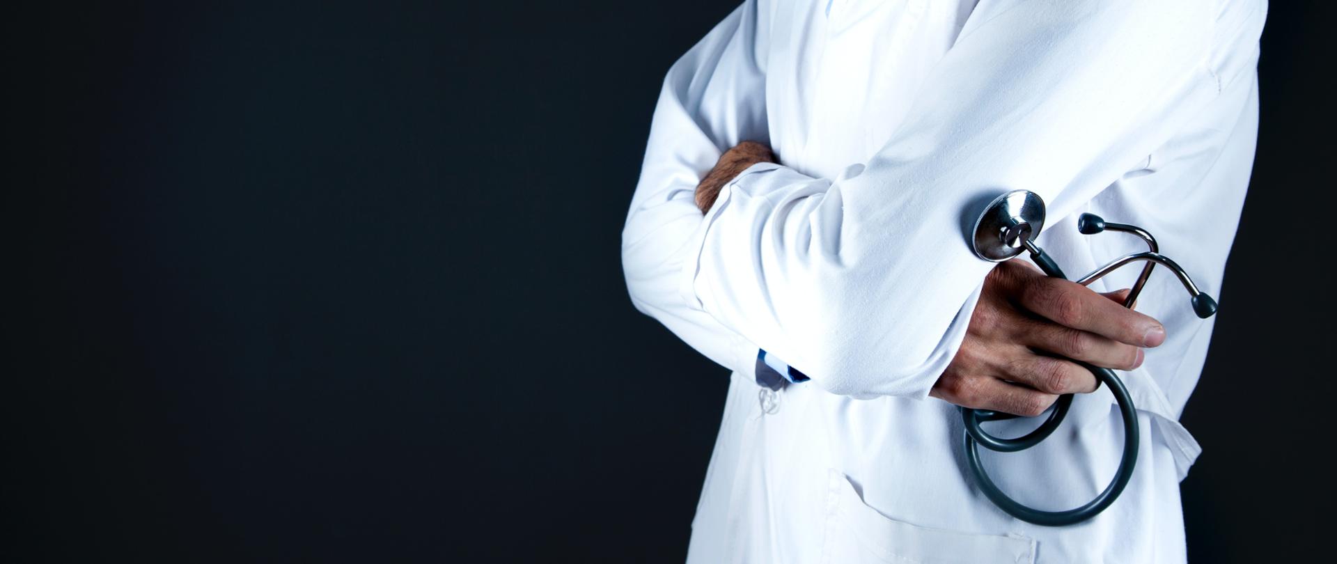 Figura lekarza ze stetoskopem na czarnogranatowym tle