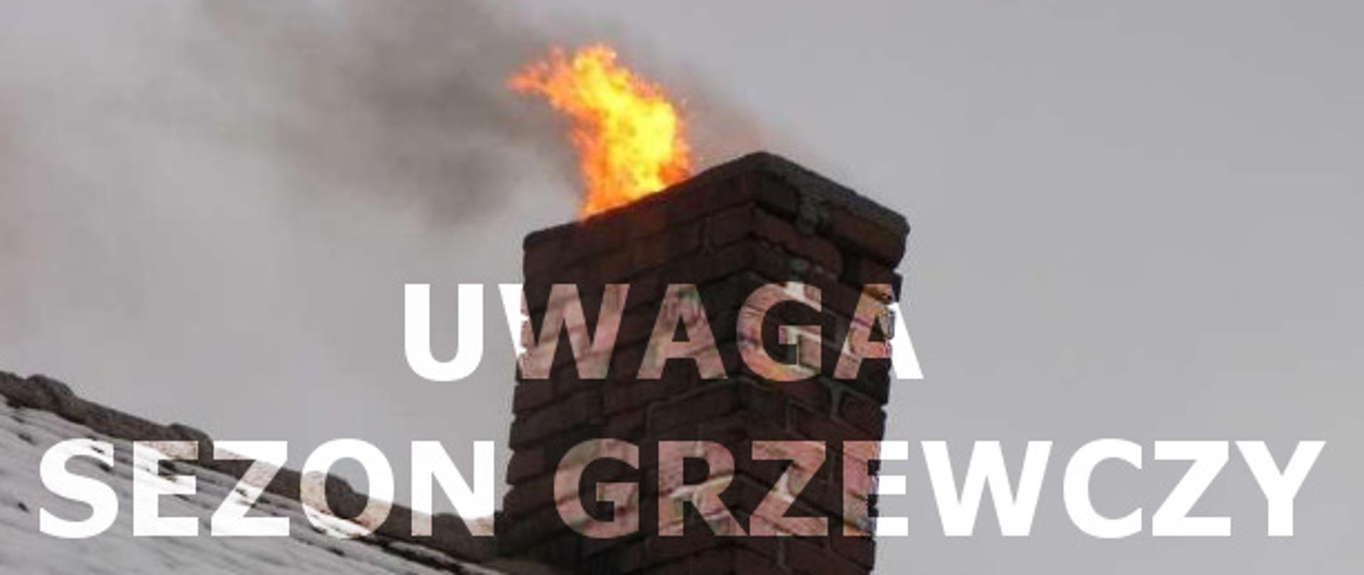Płomień i dym wydobywający się z murowanego komina na ośnieżonym dachu