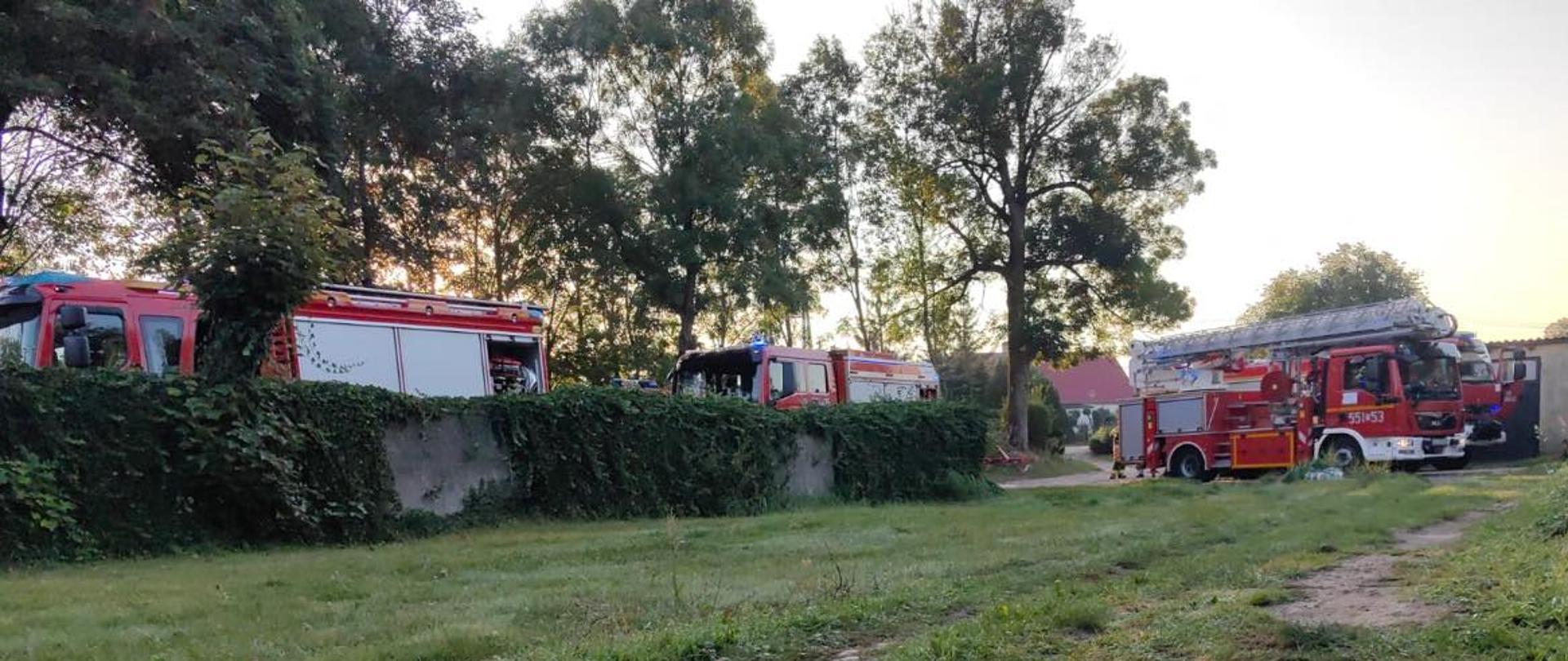 Zdjęcie przedstawia samochody strażackie podczas działań rozstawione obok siebie