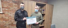 Na zdjęciu z prawej strony Nadleśniczy Nadleśnictwa Dąbrowa Karol Pawlicki przekazujący czek o wartości dwa tysiące pięćset złotych starszemu brygadierowi Piotrowi Tkaczyńskiemu Komendantowi Powiatowemu Państwowej Straży Pożarnej w Świeciu