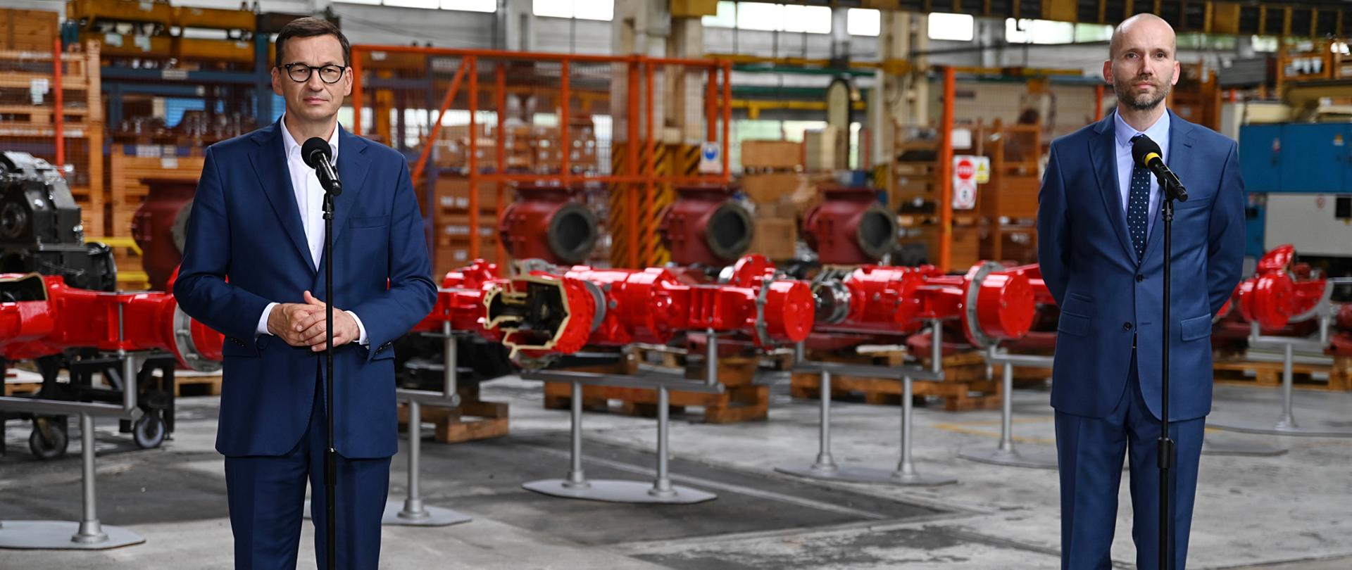 Premier oraz właściciel firmy stoją w zakładzie.