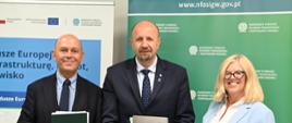 Robert Gajda, Zastępca Prezesa Zarządu NFOŚiGW, oraz przedstawiciele Aquanet S.A. pozują z podpisanymi dokumentami umowy dotyczącej inwestycji w zielono-niebieską infrastrukturę w Poznaniu.