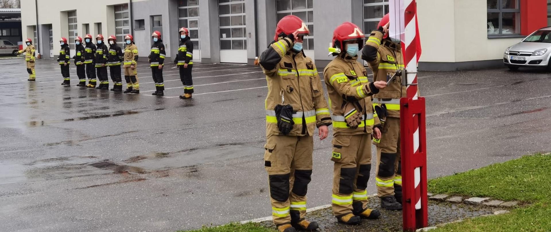 Strażacy KM PSP w Opolu uroczyście podnoszą flagę.