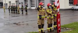 Strażacy KM PSP w Opolu uroczyście podnoszą flagę.