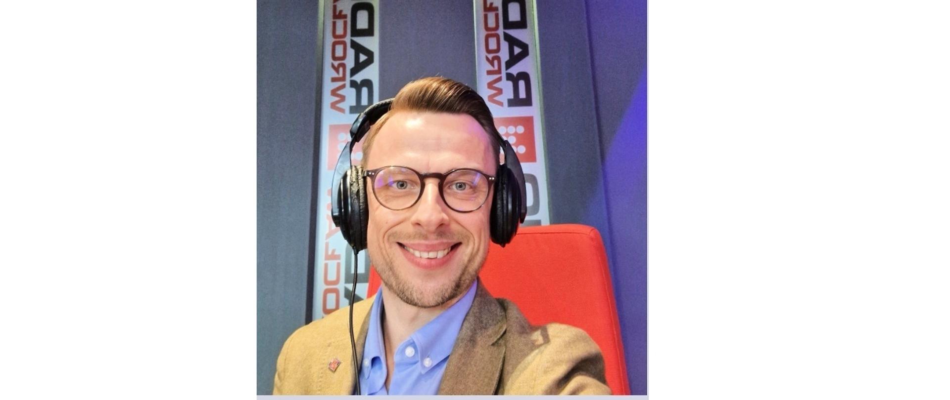 Dolnośląski Wojewódzki Inspektor Inspekcji Handlowej w Radiu Wrocław w czarnych słuchawkach w studiu Radio Wrocław