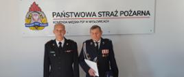 st. bryg. Olgierd Koźmiński wręcza decyzję w sprawie przyznania świadczenia ratowniczego druhowi OSP Janów z Mysłowic w tle logo PSP i napis Państwowa Straż Pożarna Komenda Miejska PSP w Mysłowicach