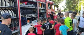 Strażacy omawiają i pokazują dzieciom sprzęt pożarniczy